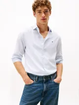 Camisa de manga larga de corte slim de la marca Tommy Hilfiger, color celeste, con cierre frontal de botones, cuello camisero clásico y pequeño logo bordado en el pecho.