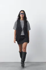 Short pollera de tiro medio con silueta recta y diseño tipo falda en el frente, confeccionado en tela de sastrería color marrón.