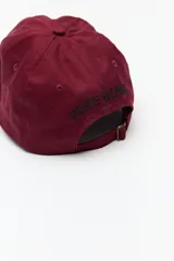 Gorra de béisbol color bordó con bordado frontal de la frase "Wild Heart" en blanco.