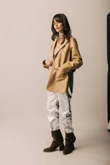 Blazer de cuero color celeste metalizado, con solapas, cierre con broches tipo tanca de madera y puños con detalle de piel sintética marrón.