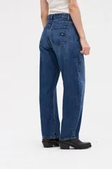 Jean de tiro alto con silueta tipo globo, ajustado en la cintura y con piernas holgadas que se estrechan hacia el bajo.