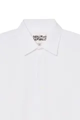 Camisa de corte regular fit confeccionada en popelín de algodón. Presenta cuello solapa, manga larga con puños abotonados y cierre frontal con botonadura.