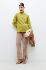 Polera de punto color verde pistacho, de corte holgado y cuello alto.