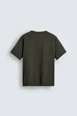 Camiseta relaxed fit color gris oscuro, confeccionada en tejido ligero de algodón con elasticidad. Presenta cuello redondo y manga ranglán corta.