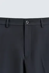 Pantalón de traje regular fit negro, confeccionado en tejido técnico transpirable Non Iron, con bolsillos frontales, bolsillos traseros de vivo y cierre frontal con cremallera y botón.