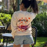 Buzo de cuello redondo en color crema, con diseño estampado en la espalda que incluye un gráfico de una copa con frutillas y la frase 'Vino con frutilla'.