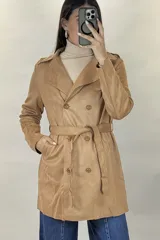 Trench de gamuza sintética color tostado, con diseño de doble botonadura, solapas clásicas y cinturón ajustable a la cintura. Cuenta con bolsillos laterales y mangas largas.