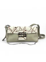 Cartera bandolera color gris con solapa de pelo blanco con estampado de círculos marrones. Cierre con botón magnético y herraje metálico plateado en forma de "S".