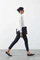 Pantalón de vestir negro de corte recto, con cintura estructurada y costura central vertical en las piernas que aporta un acabado sastrero.