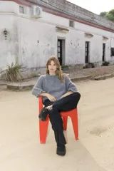 Sweater de punto grueso en color gris, con cuello redondo y mangas largas con puños ajustados.