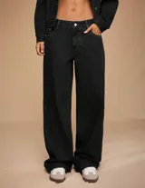 Jean wide leg de tiro medio confeccionado en denim rígido de color negro. Presenta un diseño de cinco bolsillos con cierre de botón y cremallera.