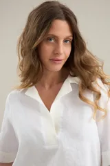Blusa blanca de lino con silueta cómoda y relajada, escote en V con cuello polo y detalles en algodón.