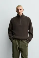Jersey de punto perlado con cuello perkins y cierre frontal de cremallera. Presenta un corte regular fit, manga larga y acabados en rib en puños y bajo.