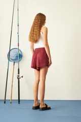 Short color borgoña de viscosa con cintura elástica ajustable con cordón, bolsillos laterales y corte holgado.