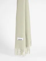 Pashmina de textura suave en color beige, con diseño liso y terminación de flecos en los extremos. Incluye etiqueta de marca cosida.