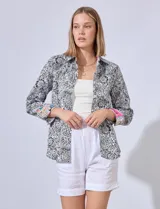 Camisa de algodón estampada en tonos celeste y blanco, con cuello con solapa, abertura central con botones y mangas largas con puños en contraste.