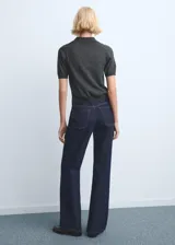 Jeans de tiro medio con diseño de corte recto y holgado, confeccionados en denim azul oscuro con costuras en contraste.