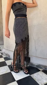 Falda asimétrica de tejido lurex negro y dorado, con pretina elástica y apliques de crochet en el ruedo.