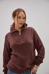 Sweater de punto color marrón chocolate, con cuello alto y cierre frontal parcial. Presenta un diseño con texturas combinadas, incluyendo paneles de punto trenzado en las mangas y el frente, y un tejido de punto texturizado en el centro.