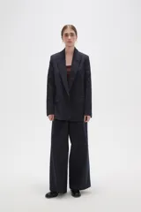 Blazer de corte holgado con diseño de rayas verticales, cuello solapa y cierre frontal con un botón. Cuenta con bolsillos laterales con solapa.