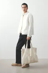 Sobrecamisa color crema de sarga de algodón, corte regular, con cuello inglés, tapeta clásica, bolsillo de parche en el pecho, mangas largas con puños abotonados y bajo recto.