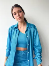 Camisa turquesa de manga larga con botones.