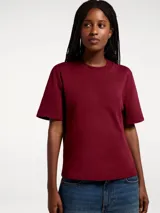 Camiseta básica de manga corta con cuello redondo, confeccionada en tejido de algodón de corte recto y ajuste holgado.