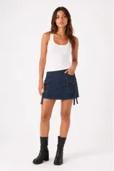 Minifalda de jean azul oscuro con diseño cargo, que incluye bolsillos laterales con solapa y detalles de tiras colgantes.
