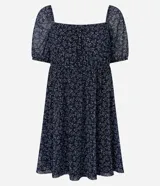 Vestido corto evasê de tule ligero color azul marino con estampado floral liberty fullprint en blanco. Posee escote recto, mangas cortas abullonadas y canesú fruncido en el busto.