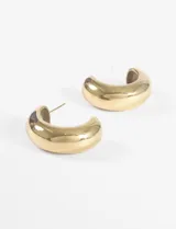 Aros plateados gruesos con forma de media luna, hechos de acero quirúrgico hipoalergénico.