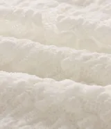 Blusa de encaje floral texturizado con forro interno, manga larga y cuello redondo. Presenta un diseño ajustado y corto, confeccionada en poliamida con un toque de elastano.