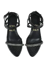 Sandalia flat negra con textura de piel de serpiente, tira delantera con strass y pulsera al tobillo con hebilla.