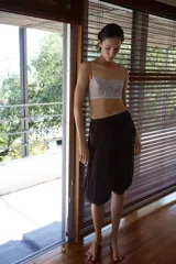 Pantalón de tiro bajo confeccionado en viscosa, con diseño abullonado y tejido plisado. Presenta detalles de apliques circulares en la cintura y terminaciones en los puños con tejido crochet a tono.