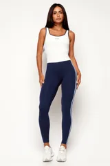 Monopieza deportiva color azul marino y blanco, con efecto bicolor que simula la combinación de una musculosa y calzas. Presenta dos tiras laterales en celeste y breteles medios.