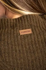 Polera de lana oversize color beige melange, con cuello alto, mangas largas acampanadas y diseño de tejido acanalado con tramas direccionales.