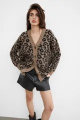 Chaqueta de punto con diseño jacquard de animal print, escote en pico, manga larga y cierre frontal con botones. Presenta un tejido con efecto cepillado y acabados en rib.