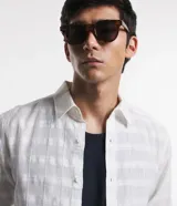 Camisa de hombre, manga larga, color beige claro, con cuello inglés y textura grid.