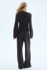 Pantalón de corte holgado confeccionado en punto fino de mezcla de algodón. Presenta un diseño de tiro alto con elástico oculto en la cintura y pliegues cosidos en la parte frontal.