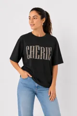 Remera de algodón color bordó, de corte holgado y manga corta, con cuello a la base y estampa frontal con la palabra 'WILD' en animal print.