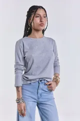 Remera básica de manga larga en color gris melange, con textura acanalada y cuello redondo.