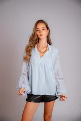 Camisa celeste de plumetí con cuello mao, mangas globo largas con puños elásticos y lazo en el escote.