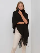 Poncho tejido negro con textura, cuello alto de velour negro y terminación con flecos largos en el ruedo.