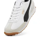 Championes urbanos Puma modelo Easy Rider Mix, color blanco con detalles en negro y beige. Presentan un diseño retro con capellada de cuero y gamuza, logo Puma dorado en el lateral y suela de goma dentada color caramelo.