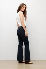 Jean bootcut de tiro medio en color azul oscuro, con diseño clásico de cinco bolsillos y cierre frontal con botón y cremallera.
