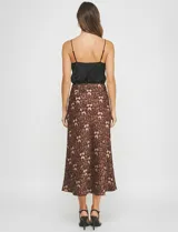 Falda midi de satén con estampado animal print en tonos marrones y negros. Corte al bies que cae ajustado en la cadera y se abre ligeramente hacia el ruedo.