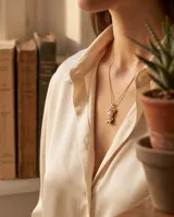 Collar de bronce con cadena fina y dije en forma de silueta de niña con perla sintética en el centro y pequeños cristales incrustados en la zona inferior.