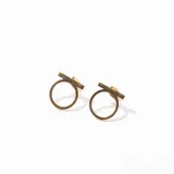 Par de caravanas doradas con forma geométrica de círculo y barra.