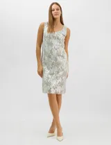 Conjunto de dos piezas compuesto por un vestido midi de silueta recta con tejido plisado metalizado y escote redondo con pedrería, acompañado por una chaqueta de gasa abierta con caída en cascada y mangas tres cuartos con puños metalizados.