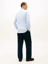 Camisa celestes de manga larga de Tommy Hilfiger, confeccionada en popelina de algodón con elastano. Presenta corte slim, cuello camisero clásico, cierre frontal con botones y el logo bordado en el pecho.