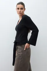 Sweater de punto acanalado color rojo, con escote en V, mangas largas acampanadas y lazo ajustable en la cintura.